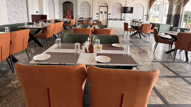 A spacious dining area with high ceilings, modern furniture, and a mix of seating arrangements. - Hotel Mumbai House - Pithampur (Pithampur)