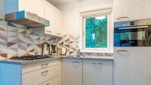 A modern kitchen with a gas stove, coffee maker, and Bosch oven. - Tastefully and Modernly Furnished 5-person Bungalow (De Waal)