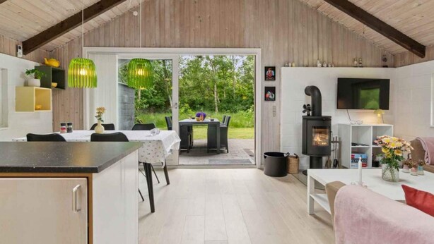 A modern kitchen with a dining area, a fireplace, and a TV. - 4 Star Holiday Home in Hurup Thy (Hurup Thy)