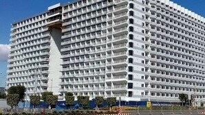 Un grand hôtel moderne à la façade structurée en forme de grille et doté de nombreux balcons.