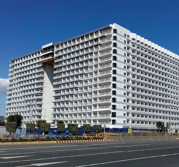 A large, modern hotel with a grid-like facade and multiple balconies.