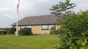 Un bâtiment à deux étages, doté d’une façade en briques et d’un toit recouvert de tuiles.