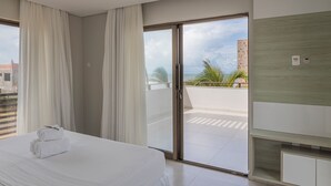 Une chambre d’hôtel avec un lit, une porte-fenêtre coulissante donnant sur un balcon et une vue sur le paysage urbain.