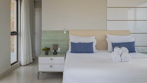Une chambre d’hôtel moderne équipée d’un lit, d’une table de chevet, d’une lampe et d’une fenêtre avec des rideaux.
