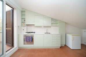 A compact kitchen with a gas stove, oven, and a refrigerator.