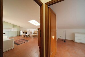 A spacious living area with a dining table, chairs, a sofa, and a kitchen in the background. - BuddyRent - Juan's Trevi - Terrace - 6 guests (Roma)