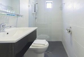 Een haardroger, handdoeken, zeep, toiletpapier