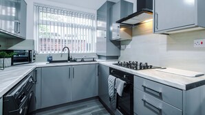 Una cocina moderna con horno integrado, microondas y lavavajillas.