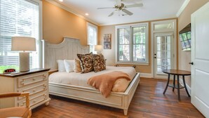 Un dormitorio con cama, cómoda, mesita de noche, lámpara y ventilador de techo.