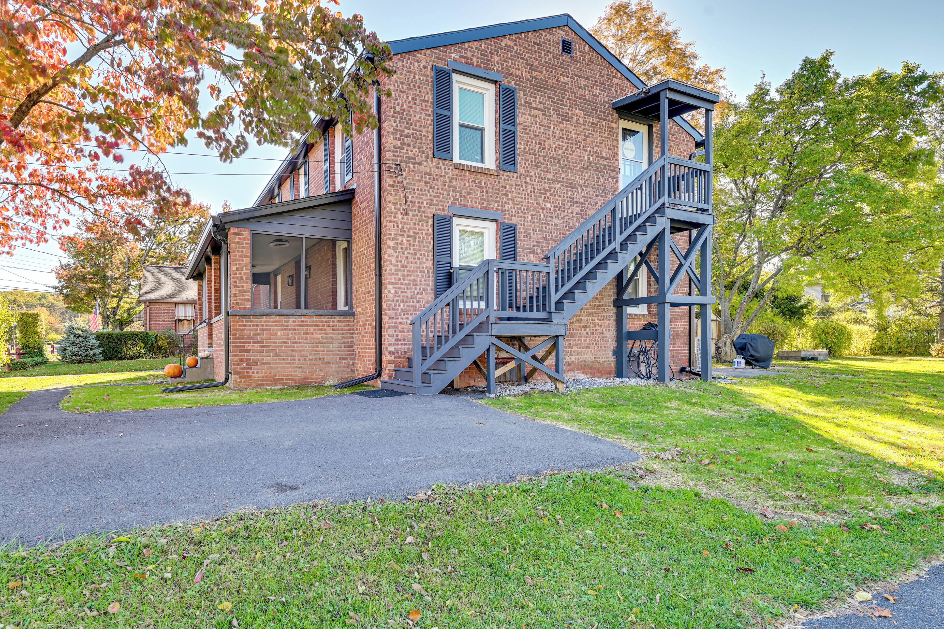 A two-story brick building with a covered porch, a staircase, and a garage.