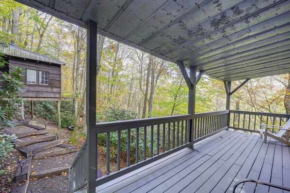 A wooden deck with a railing, a bench, and a small cabin in the background. - Families Welcome! Blue Ridge Cabin w/ Fire Pit (Banner Elk)