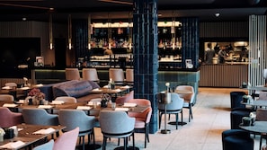 A modern bar area with seating and a bar counter. - 4K Hotel (Wangen im Allgäu)