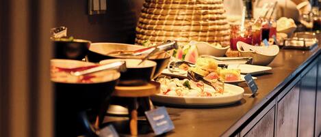 A buffet setup with various dishes and a wicker basket.