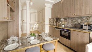Une cuisine moderne avec des comptoirs en marbre, des armoires en bois et des éléments décoratifs dorés.