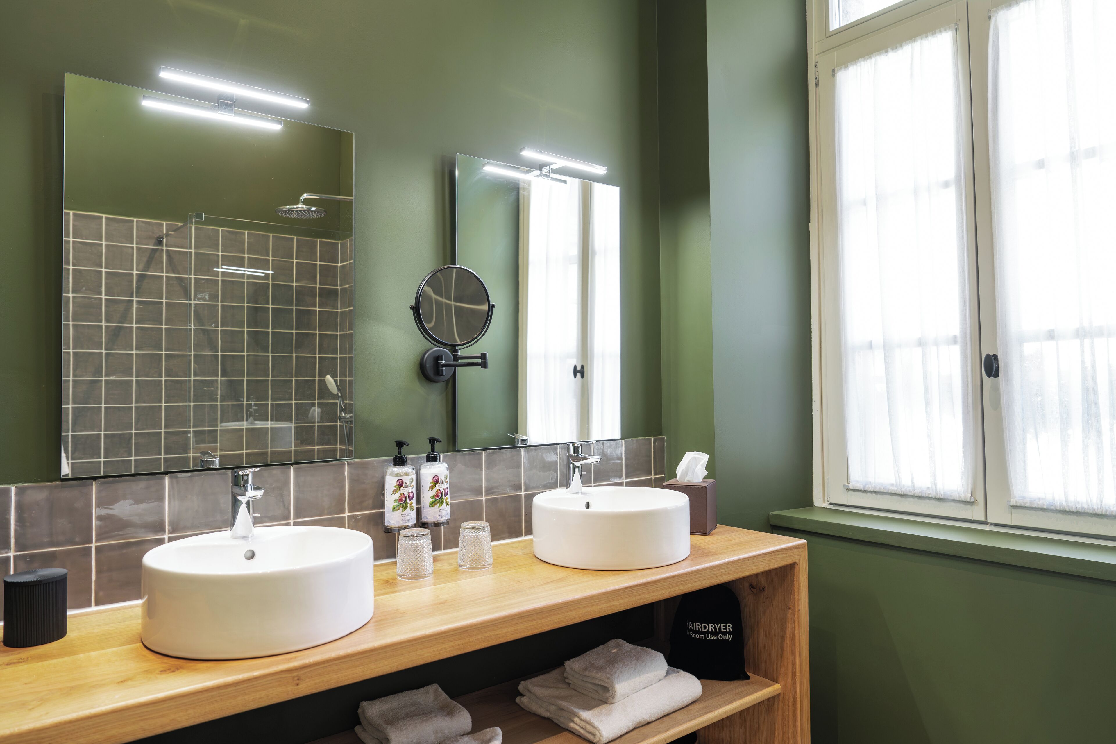 A bathroom with two sinks, a mirror, and a window.