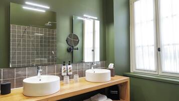Un bagno con due lavabi, uno specchio e una finestra.