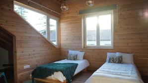 A cabin with two beds, wooden walls, and large windows. - largobispohostel (Horta)