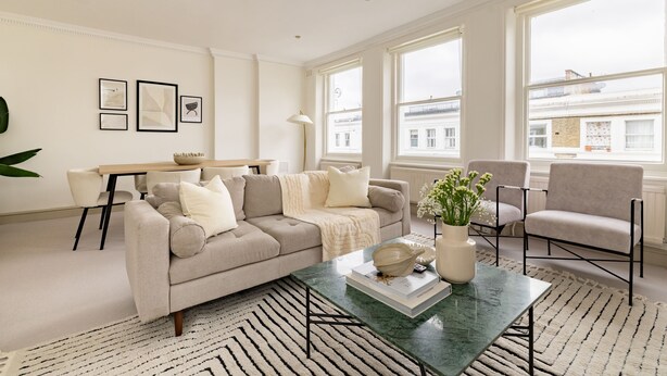 A modern living room with a sofa, armchairs, a coffee table, and a dining area. - Stylish West Kensington Duplex (London)