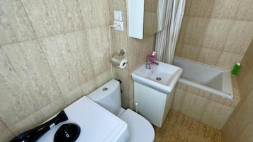 Een haardroger, handdoeken, zeep, toiletpapier