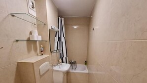 A compact bathroom with a toilet, sink, and bathtub.