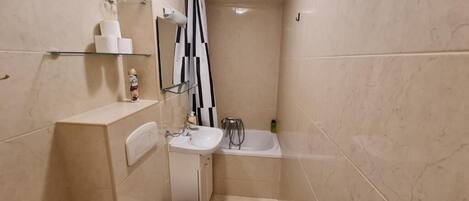 A compact bathroom with a toilet, sink, and bathtub.