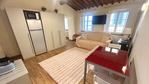 A compact living space with a kitchenette, a dining area, and a sofa. - Owl Palace, Royal Owl in Center Town (Lucca)