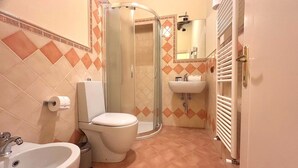 Ein Badezimmer mit Toilette, Waschbecken und Dusche.