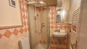 Un baño con ducha, inodoro, bidé y lavabo.