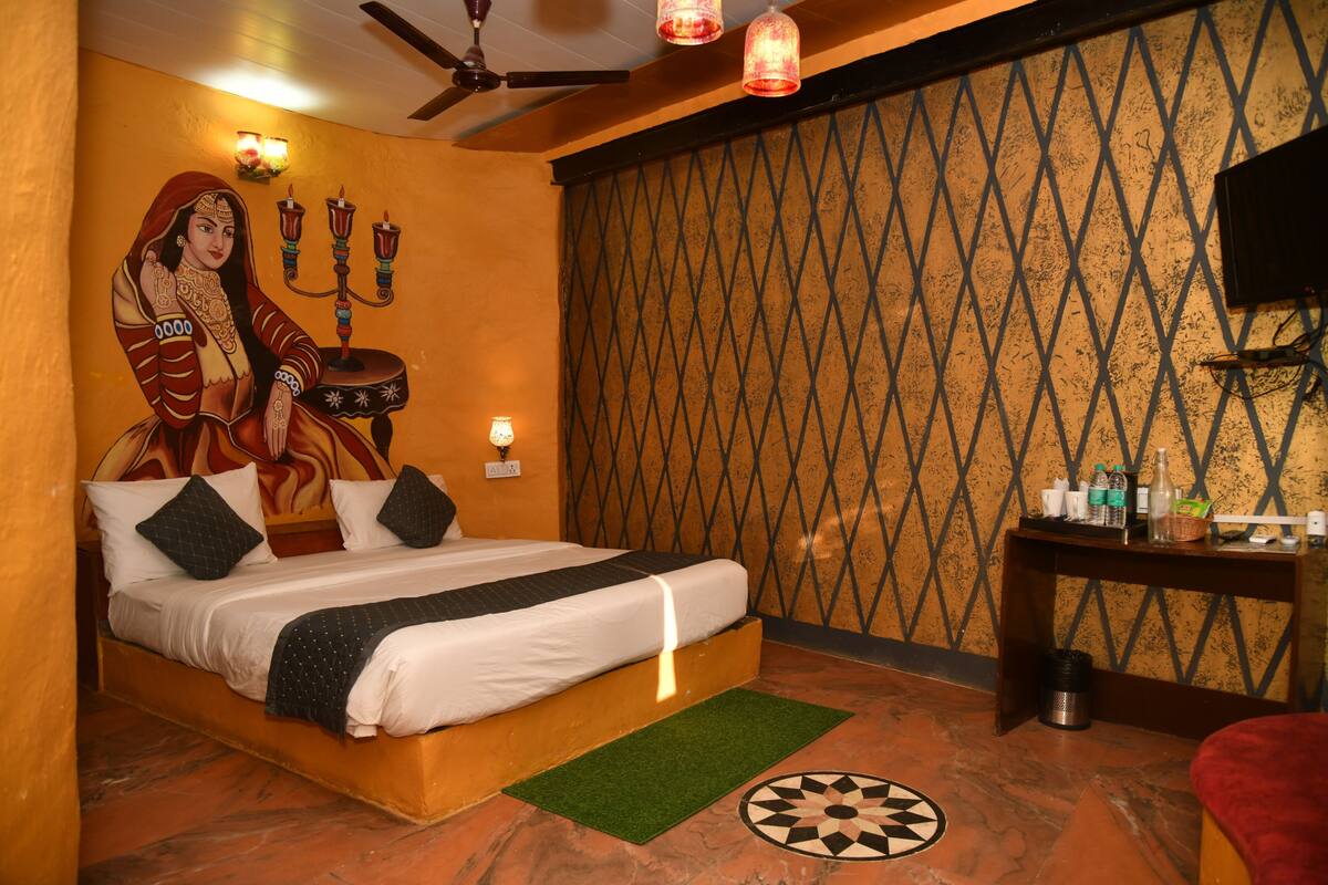 A room with a bed, a wall mural, a ceiling fan, and a wall-mounted TV.