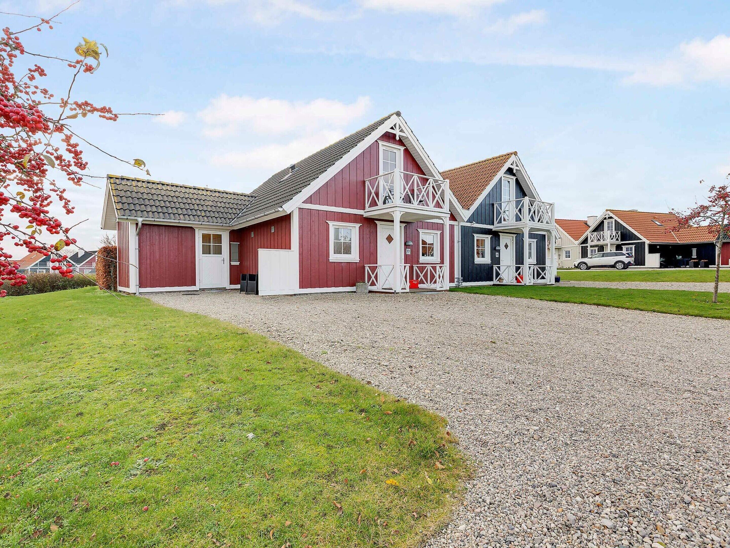 A row of traditional Scandinavian-style houses with a gravel driveway and a grassy lawn.
