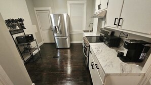 A compact kitchen with stainless steel appliances, a marble countertop, and a black coffee maker. - 2BR Apartment Near Wesleyan 102 (Middletown)