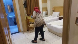 A hotel room with two beds, a bathroom, and a wooden chair. - New Pharoah's Palace hotel (Cairo)
