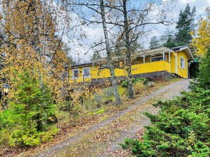 A yellow building with a porch, surrounded by autumn foliage and trees. - 4 Star Holiday Home in Bergshamra (Bergshamra)