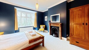 Une chambre à coucher comprenant un lit, une chaise, une cheminée et une armoire.