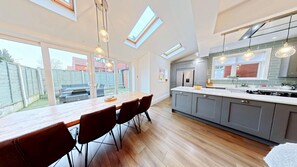 A modern kitchen with a dining area, skylights, and a view of the backyard. - Peasholm Place -  a cottage that sleeps 8 guests  in 5 bedrooms (Scarborough)
