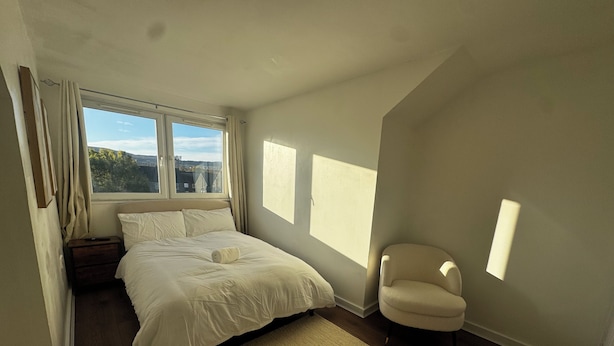 A bedroom with a bed, a chair, a window, and a view of the outdoors. - Spacious 4BR Home Near Edinburgh Airport and City Centre – Parking (Edinburgh)