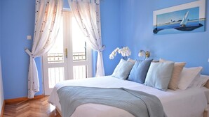 Une chambre à coucher avec un lit, des rideaux, un tableau et une table de chevet.