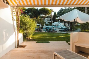 A patio area with outdoor seating, a pool, and a covered section with umbrellas. - Bonita V3, 431 R/C, Vista Piscina da Baleia, resort Balaia Golf Village, (Albufeira)