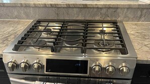 Une cuisine en acier inoxydable dotée d’un four encastré et d’un panneau de commande numérique.