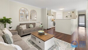 A modern living room with a sofa, coffee table, and potted plants. - 3 bedroom Villa walking distance to Mandurah foreshore (Mandurah)