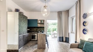 Een moderne keuken met een centraal eiland, een zithoek met een bank en uitzicht op de omgeving.
