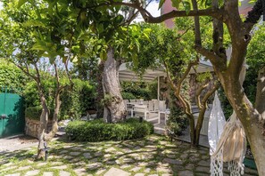Un jardin agrémenté d’une pergola, d’un espace détente et d’un chemin en pierre.