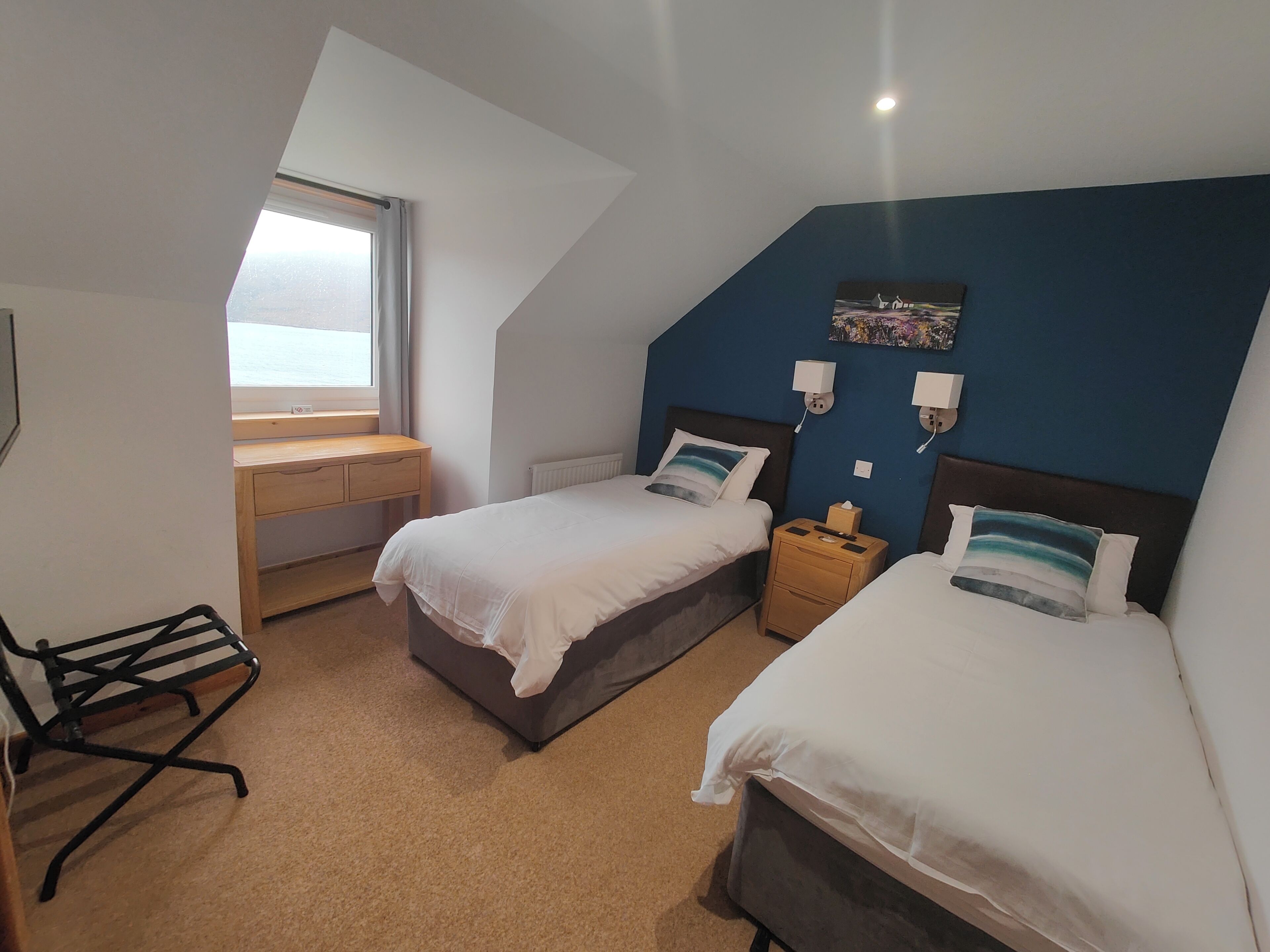 A room with two beds, a desk, and a chair.