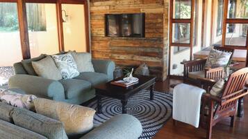 Chalet Deluxe, 3 habitaciones | Área de sala de estar | Televisión LCD de 64 pulgadas con canales por cable