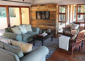 Chalet Deluxe, 3 habitaciones | Área de sala de estar | Televisión LCD de 64 pulgadas con canales por cable