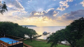 A pool area with a wooden deck and a view of the sea. - Sobhengu Lodge by Dream Resorts (KwaNibela)