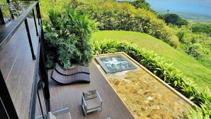 A terrace with outdoor furniture, a hot tub, and a view of a lush landscape. - Landscape Suite (Cerritos)