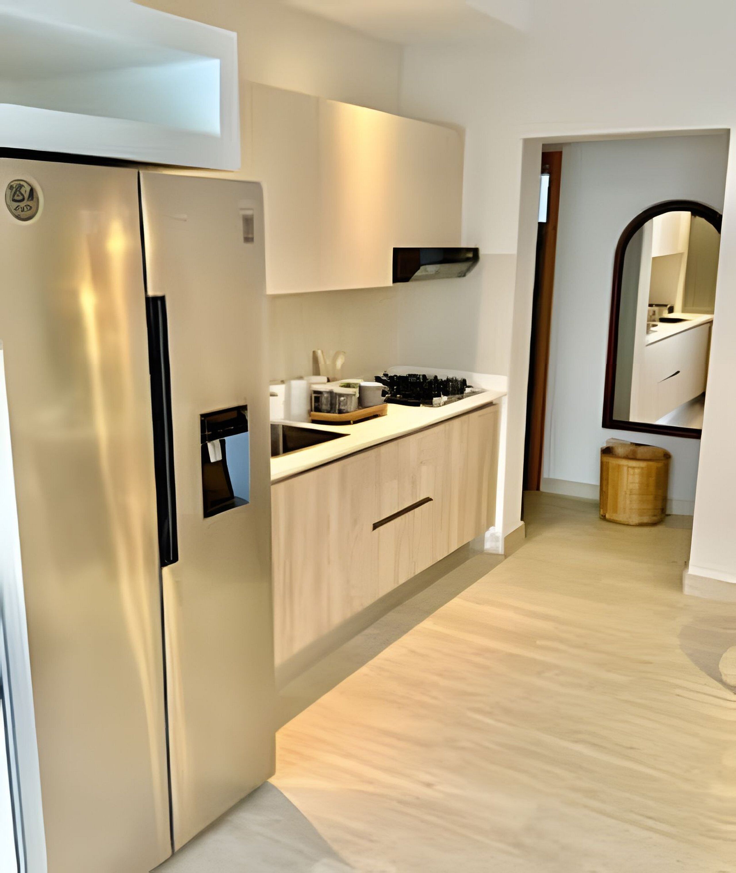 Una cocina moderna con refrigerador empotrado, armarios de madera y una encimera con utensilios de cocina.