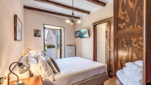 Ein Schlafzimmer mit Bett, Nachttisch, Lampe und einer Holztür.