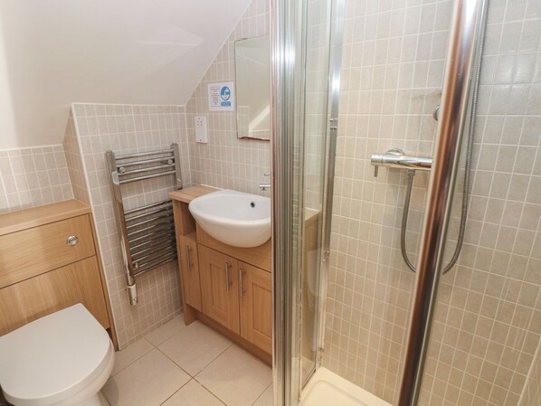 Une salle de bain avec des toilettes, un lavabo et une douche.